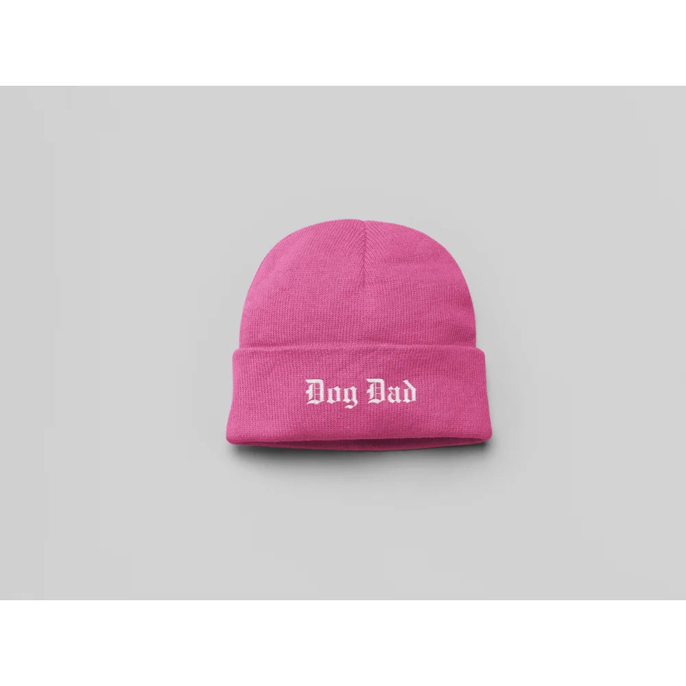 Bonnet en tricot rose vif avec âDog Dadâ brodé en texte blanc.