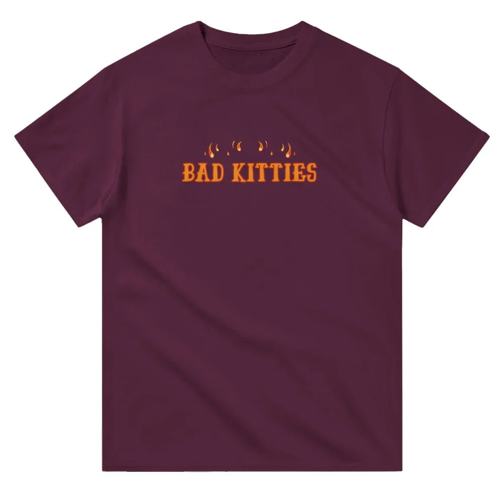 T-shirt marron avec ’BAD KITTIES’ imprimé en orange et des empreintes de pattes de chat au-dessus.